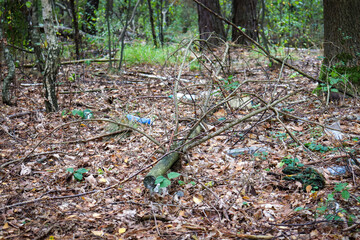 Naklejka na ściany i meble Garbage problem in the forest . Plastic trash in the forest. Tucked nature. World ecology problem. Save the world concept
