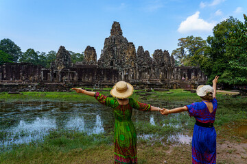 Cambodia. Siem Reap. The archaeological park of Angkor. A couple of women in front of Bayon Temple 12th century Hindu temple