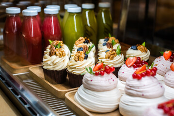 Mini Pavlova dessert on a candy bar, wedding buffet table. cakes decorated berries and fruits