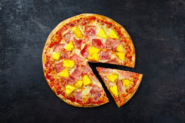 Traditional Italian pizza Hawaii with ham, pineapple and mozzarella served as top view on an old...