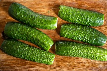 Preparation of beaten cucumbers. Halves of fresh cucumbers on a cutting board.