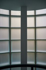Interior of building looking at opaque of curved window constructed from glass blocks during daytime