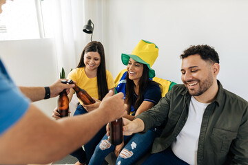 Host bringing beers to group of friends watching a football match on TV