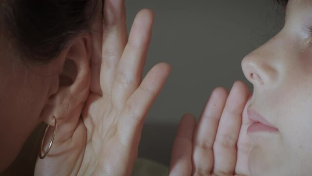 Small secret to mum ear. A view of daughter telling secrets to her mother in the room. Secrets of a child.