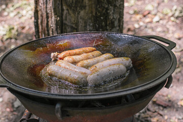 sausages fried in a cauldron