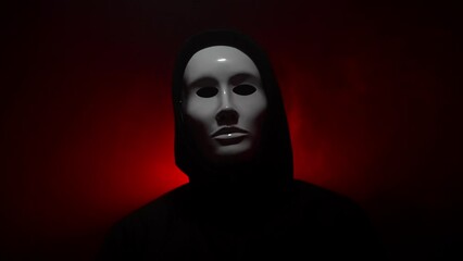 Man wearing mask with hoodie on red background.