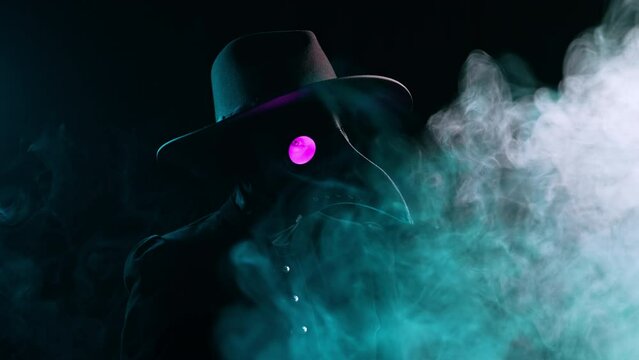Plague doctor with crow-like mask isolated on black smoke background. Creepy raven mask, halloween, historical terrible protection costume, mystical fantasy. Epidemic