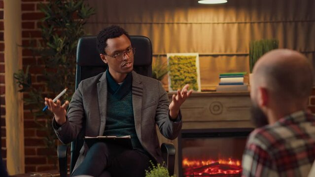 Marriage counselor attending psychotherapy session in psychology office, listening to people with relationship problems. Male therapist doing counseling psychoanalysis at meeting.