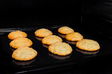 Nine baked homemade crunchy oatmeal cookies on metal sheet in oven. Dessert, cookery, baking,...