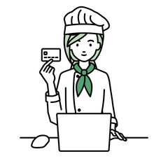 デスクで座ってPCを使いながらクレジットカードを手に持っている調理師の女性