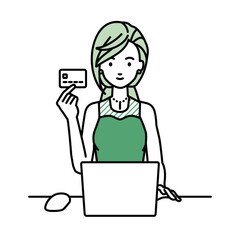 デスクで座ってPCを使いながらクレジットカードを手に持っているドレスの女性