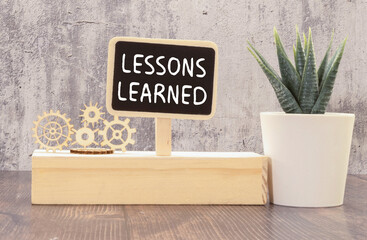 glasses and a notebook with the inscription LESSONS LEARNED