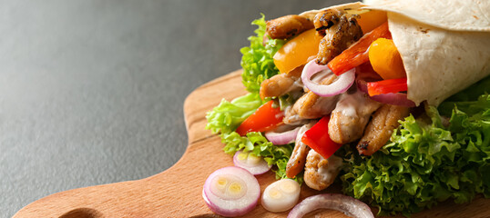 Board with tasty doner kebab on grey background