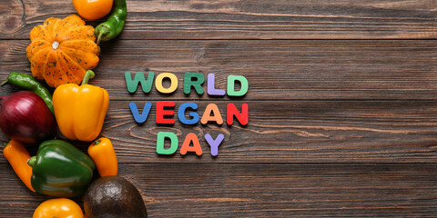 Text WORLD VEGAN DAY and fresh vegetables on wooden background with space for text