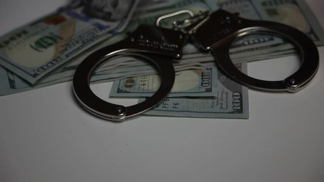 Police Lights Flashing onto Handcuffs and 100 Dollar Bills