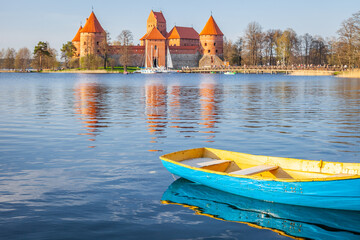Trakai castle with boat floating on water in foreground, Lithuania