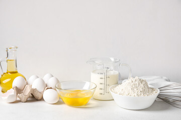 Different ingredients for baking on table against white background