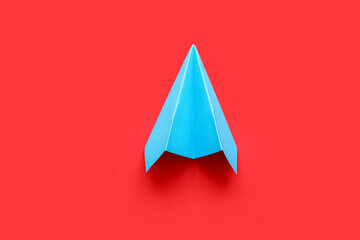 Fototapeta premium Blue paper plane on red background