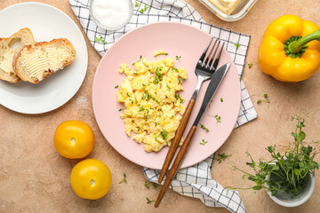 Composition with plate of tasty scrambled eggs, vegetables green sprouts and bread on color background
