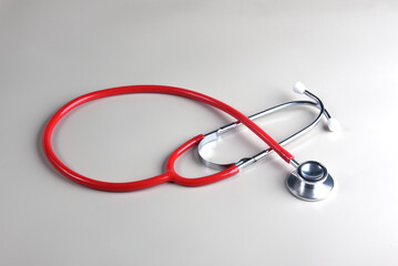 Red beautiful therapist's stethoscope on a white background