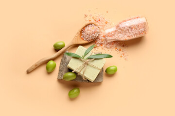 Soap bar, bottle of sea salt and green olives on color background