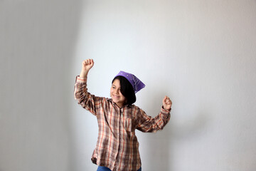 10-year-old Hispanic girl wears a purple headscarf representing the struggle for feminism and...
