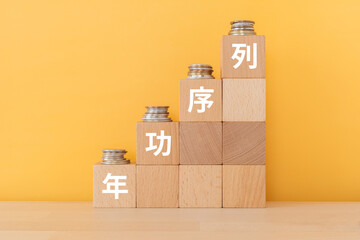 年功序列と書かれたブロックとコイン
