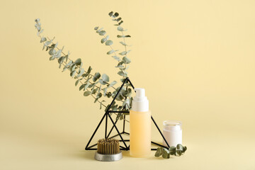 Fototapeta na wymiar Cosmetic products with kenzan, eucalyptus branches and decor on beige background