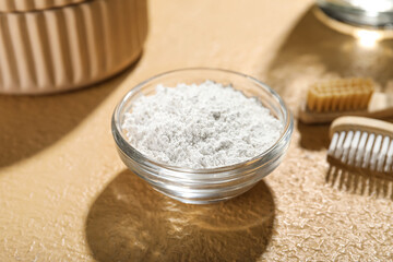 Bowl of tooth powder on beige background, closeup