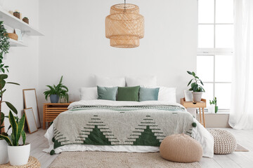 Interior of light bedroom with houseplants and poufs