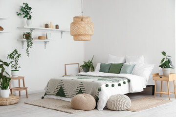Interior of light bedroom with houseplants and poufs
