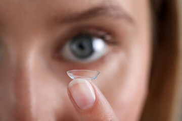 Young woman with contact lens, closeup view