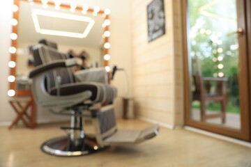 Blurred view of stylish barbershop interior with hairdresser workplace