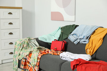 Messy pile of clothes on sofa in living room