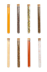 Set of glass tubes with different spices on white background, top view