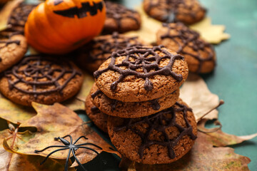 Halloween spiderweb cookies with fallen leaves on grunge background, closeup
