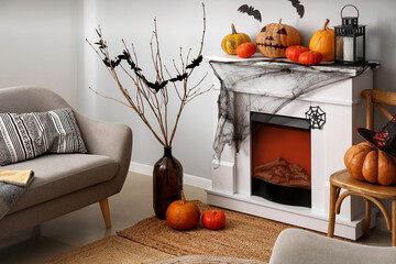 Interior of living room decorated for Halloween with fireplace, pumpkins and sofa