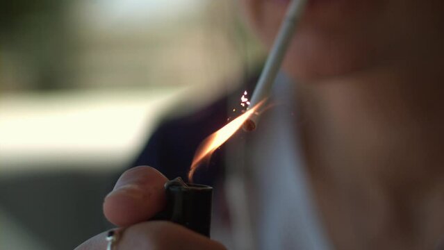 Woman lighting a cigarette in super slow motion in summer