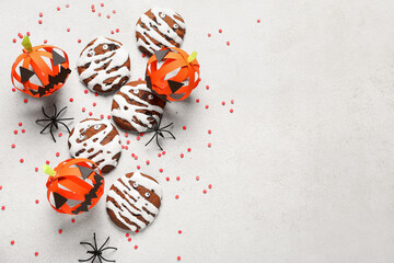 Halloween mummy cookies, spiders, paper pumpkins and sprinkles on white background