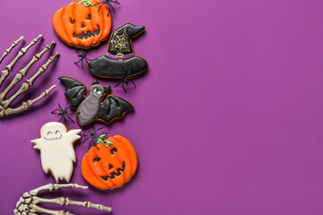 Tasty Halloween cookies and skeleton hands on purple background