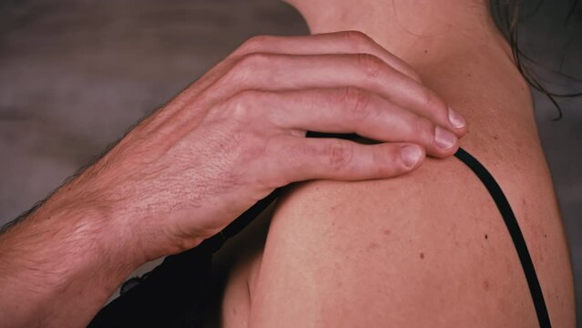 Fingers of a man unfasten a black bra on a woman. Close-up of the back of the girl and the clasp on the bra. Man and woman undress erotic and sexy