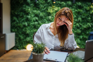 One female young adult woman sitting at the restaurant or hotel working and prepare for business meeting online using computer laptop and paper documents copy space