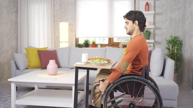 Disabled young man eating at home.
The young disabled person, who is at home with his wheelchair, is eating.

