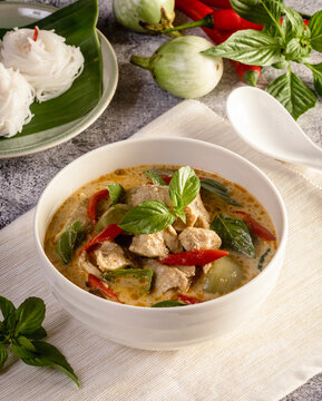 Thai food, green curry chicken with coconut curry on a wooden table.