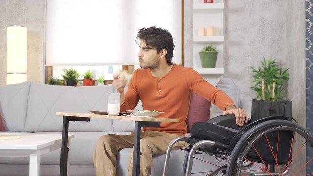 The physically disabled young man is at home.
Disabled young man is happy at home and eating.
