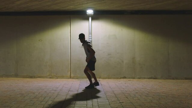 Hip hop man dancer with talent, energy and urban dancing in spotlight or street light for youth, fitness and wellness lifestyle. Gen z teenager dance with fitness body and creative breakdance outdoor