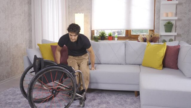 Disabled young man with panic attack and afraid.
The disabled young man, who is alone at home, gets out of his wheelchair, goes to the sofa and looks to his right and left in fear.
