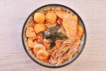 Singapore laksa - spicy noodle soup with noodles, prawns,  chicken, tofu, fishball served in spicy curry coconut milk 