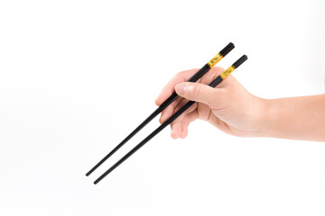 female hand holds black chopsticks isolated on white background.