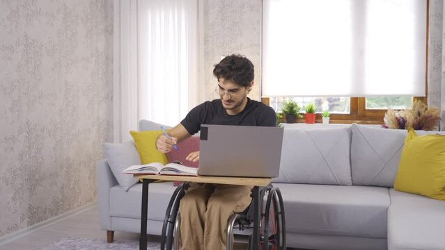 Disabled student working with laptop at home.
Disabled student working with laptop at home studying for his lessons.
